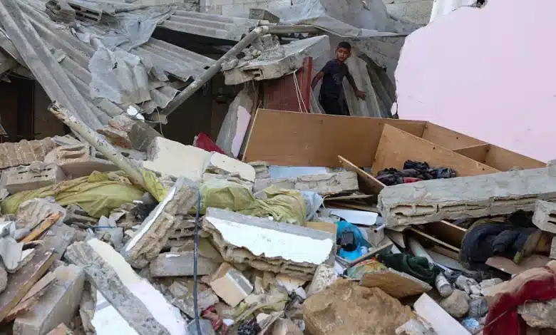 Photo de Un garçon palestinien regarde les dégâts alors qu’il se tient sur les décombres après un Israélien.