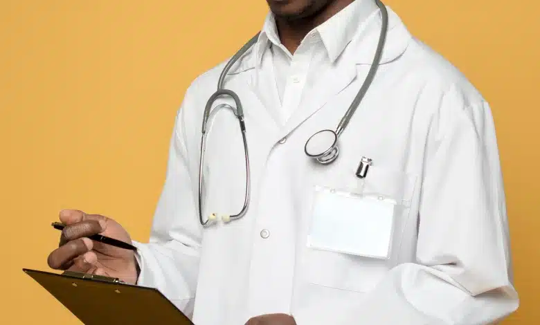 Close-up of a male doctor's hand reading the medical report on clipboard Source : Freepik