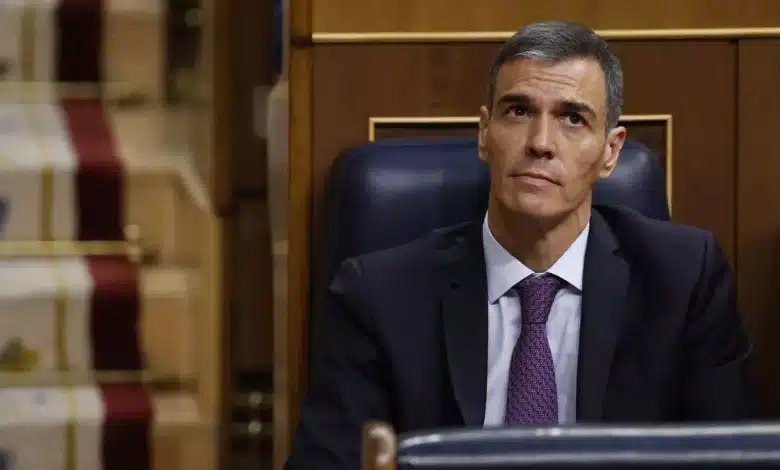 Pedro Sánchez assis au Congrès des députés espagnol, en costume sombre et cravate, regard tourné vers le haut.