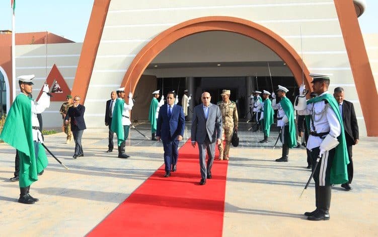 Le Président Mohamed Ould Cheikh El Ghazouani marche sur le tapis rouge, accueilli avec les honneurs militaires à l’aéroport avant sa visite à Mbout pour le lancement de projets hydrauliques.