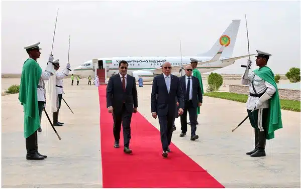 Le Président Mohamed Ould Cheikh El Ghazouani débarquant à Nouakchott, accueilli sur un tapis rouge, gardes d’honneur et avion présidentiel en arrière-plan.