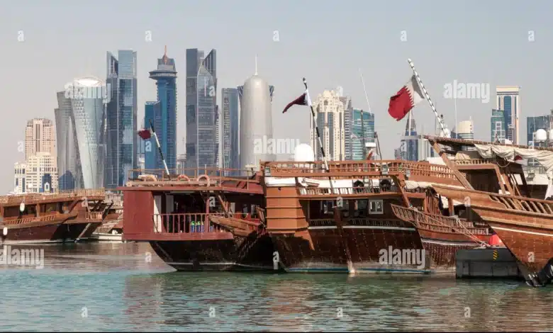 Boutres traditionnels sur la corniche de Doha avec les gratte-ciels en arrière-plan, illustrant le rôle du Qatar comme pont entre tradition et diplomatie moderne.