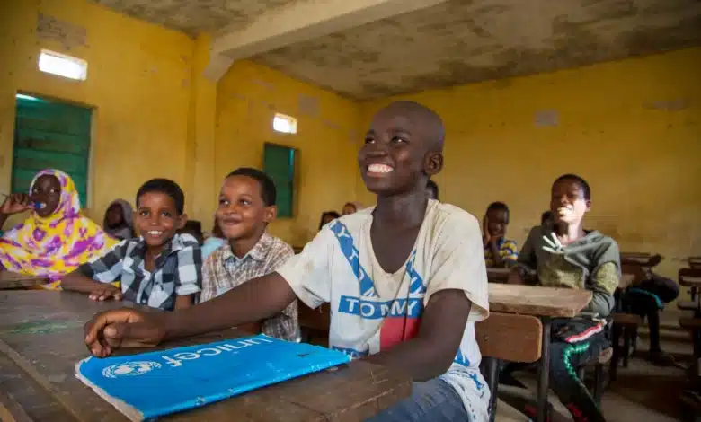 Des élèves mauritaniens souriants assis dans une salle de classe d’école publique, symbolisant l’espoir et les défis du système éducatif national.