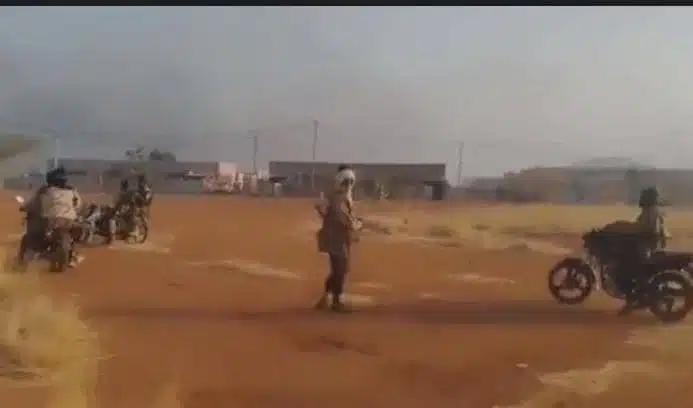 Des combattants armés du JNIM circulant à moto dans une zone rurale du Mali.