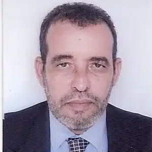 Portrait formel d’un homme en costume, illustrant un article sur les discours politiques et le développement en Afrique