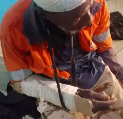 Homme blessé avec bandages à la tête et au bras recevant des soins dans un centre médical après les violences à Haayre Gollere.