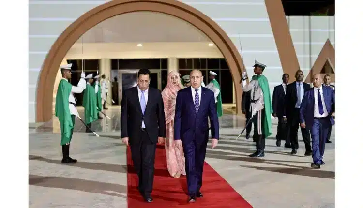 Mohamed Ould Ghazouani attendu en visite d’État à Paris : un tournant diplomatique au cœur des enjeux sahéliens 1 Le président mauritanien Mohamed Ould Cheikh El Ghazouani marchant sur un tapis rouge lors d’une cérémonie officielle, entouré de gardes d’honneur, illustrant les relations diplomatiques entre la Mauritanie et ses partenaires internationaux.