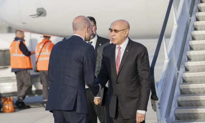 Relations Mauritanie-France : Ce que la visite de Ghazouani à Macron révèle sur la nouvelle Mauritanie 1 Le Président mauritanien Mohamed Ould Cheikh El Ghazouani, portant des lunettes de soleil, est accueilli par une poignée de main officielle sur le tarmac de l'aéroport d'Orly à Paris, lors de son arrivée pour sa visite d'État en France, le 14 avril 2026. L'escalier de l'avion et du personnel au sol sont visibles en arrière-plan.