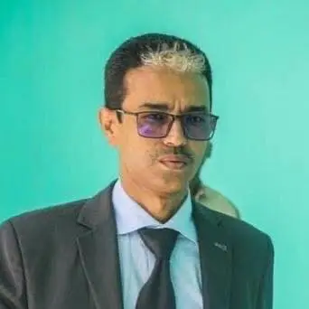 Diplomatie et retenue : Pourquoi la Mauritanie doit éviter l'ingérence verbale 2 Portrait d'Ahmed Issa El Yedali en costume noir et lunettes sur fond vert clair.