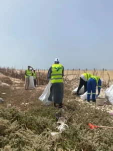 Environnement : la SNIM et les associations locales s’unissent pour assainir le littoral de Cansado 3 Bénévoles en gilets de sécurité nettoyant la végétation côtière et la zone dunaire de Cansado.