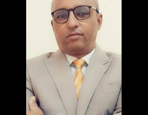 Adieu, l’Amérique ? 1 Portrait de Cheikh Ahmed ould Mohamed, ingénieur et auteur mauritanien, portant un costume et des lunettes