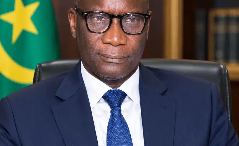 OÙ ALLONS-NOUS ? (Réponse à mon doyen Ahmed Ould Sidi Baba) — Par Gourmo Abdoul Lô 1 Portrait en costume sombre du professeur Gourmo Abdoul Lô devant le drapeau mauritanien