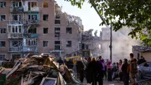 Ukraine : Un haut lieu scientifique à Kyiv ciblé par une frappe russe, quelques mois après la visite de journalistes mauritaniens 3 Secouristes et habitants devant un immeuble résidentiel détruit par une frappe aérienne en Ukraine