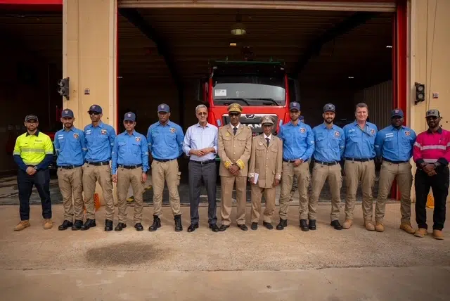 Kinross Tasiast : visite officielle du Ministre des Mines et de l’Industrie 1 Photo de groupe de la délégation officielle menée par le ministre des Mines et de l’Industrie aux côtés des dirigeants et des équipes de sécurité de Kinross Tasiast devant un camion d'intervention.