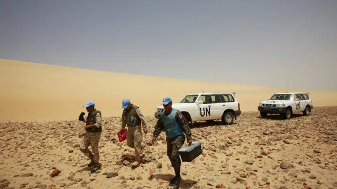 Sahara occidental : fin de la MINURSO et avenir incertain de la mission de l'ONU 1 Des observateurs militaires de la mission MINURSO de l'ONU patrouillant dans le désert du Sahara occidental à côté de véhicules blancs marqués des lettres UN.